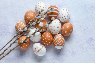 Painted Easter eggs and willow branches on light background