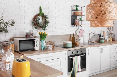 Interior of light kitchen with Easter wreath and white counters