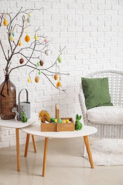 Interior of living room with Easter decor, tables and armchair