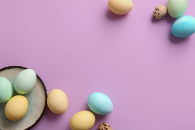 Plate with beautiful Easter eggs on lilac background