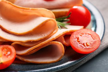 Plate with slices of tasty ham and tomatoes, closeup
