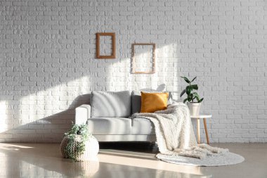 Interior of living room with grey couch and houseplants