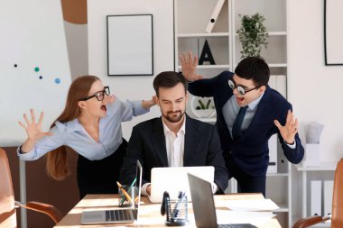 Colleagues with funny disguise and their boss in office. April Fools' Day celebration