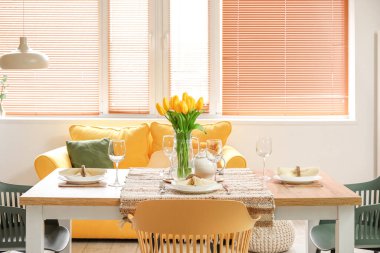 Table setting for International Women's Day celebration with tulip flowers in interior of room