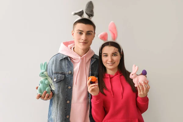 Šťastný Mladý Pár Zajíček Uši Velikonočními Vejci Králíky Šedém Pozadí — Stock fotografie