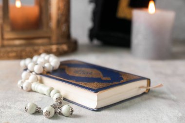 Koran with prayer beads for Ramadan on grunge table, closeup