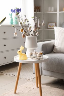 Ağaç dallı vazo, Paskalya yumurtası ve tavşanı oturma odasında.