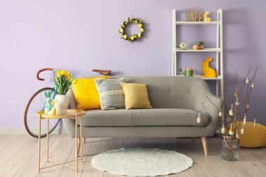 Interior of living room with Easter wreath and grey sofa
