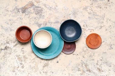 Composition with clean ceramic plates and bowls on grunge background