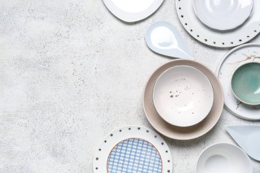 Composition with clean ceramic plates and bowls on white background