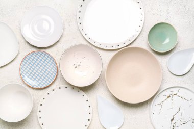 Composition with clean ceramic plates and bowls on white background