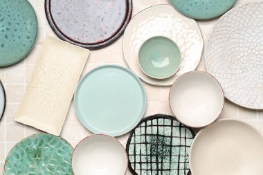 Composition with clean ceramic plates and bowls on tile background
