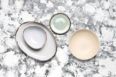 Composition with clean ceramic plates on grey grunge background