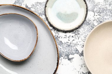 Composition with clean ceramic plates on grey grunge background