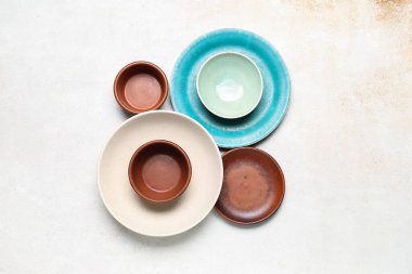 Composition with clean ceramic plates and bowls on white background