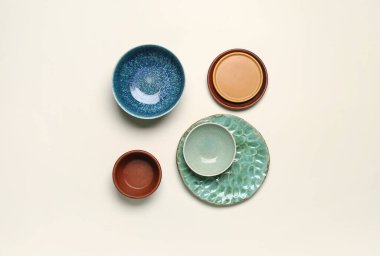 Composition with clean ceramic plates and bowls on white background
