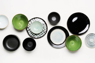 Composition with clean ceramic plates and bowls isolated on white background