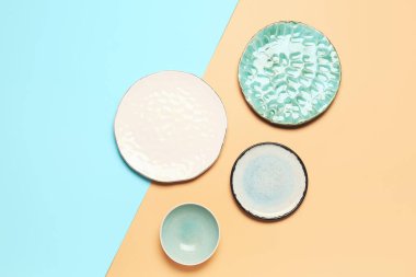 Composition with clean ceramic plates on blue and beige background