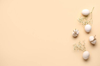 Composition with Easter eggs and gypsophila flowers on beige background