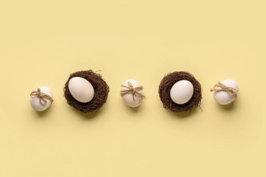 Easter eggs in nests on beige background