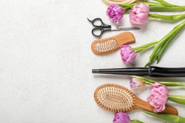 Hairdresser's tools with tulips on white background. Hello spring