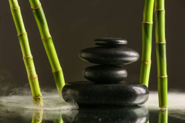 Stack of spa stones and bamboo on black background