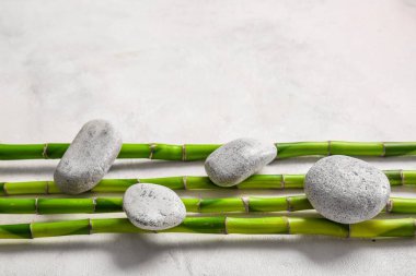 Spa stones and bamboo on white background, top view