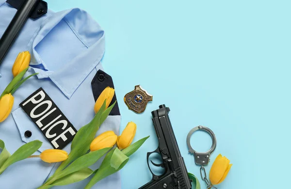 Policeman\'s uniform with items and tulips on blue background. Hello spring
