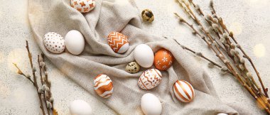 Composition with beautiful Easter eggs and pussy willow branches on light background