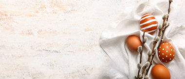 Easter eggs and pussy willow branches on light background with space for text