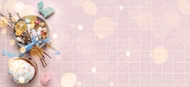Beautiful Easter eggs, pussy willow branches, bunnies and tasty cake on light pink background with space for text