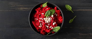 Bowl with tasty beet risotto on dark wooden background, top view