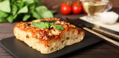 Tasty Italian pie with mozzarella and pesto sauce on wooden table, closeup