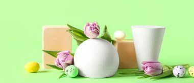 Empty podiums with Easter eggs and tulip flowers on green background