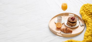 Tray with sweet breakfast on bed. Banner for design