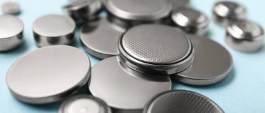 Lithium cell batteries on light blue background, closeup
