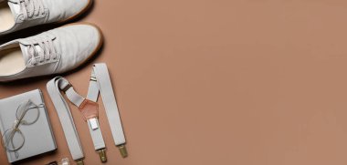Stylish man's look with suspenders and notebook on brown background with space for text