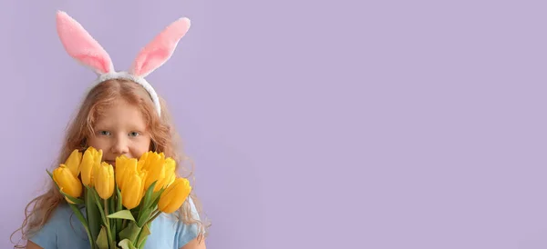 Lustiges Kleines Mädchen Mit Osterhasenohren Und Blumen Auf Fliederfarbenem Hintergrund — Stockfoto