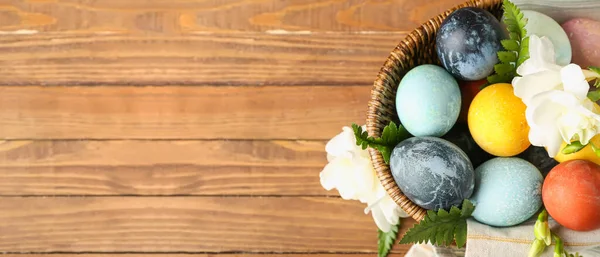 Wicker Basket Easter Eggs Flowers Wooden Background Space Text Top — Stok fotoğraf