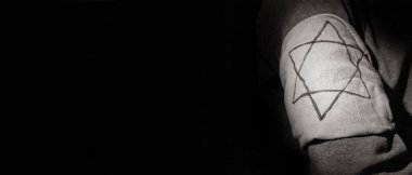 Jewish man with armband on dark background with space for text, closeup. International Holocaust Remembrance Day