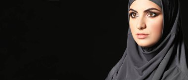Beautiful Muslim woman on dark background with space for text
