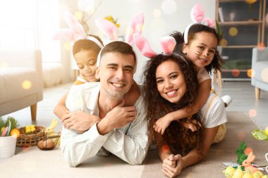 Happy interracial family in Easter bunny ears at home