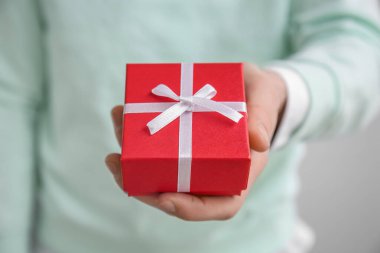Man with gift box for Valentine's Day on grey background, closeup