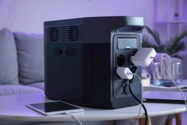 Portable power station charging devices on table in living room