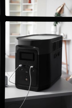 Portable power station charging devices on table in room