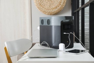 Portable power station charging devices on table in office