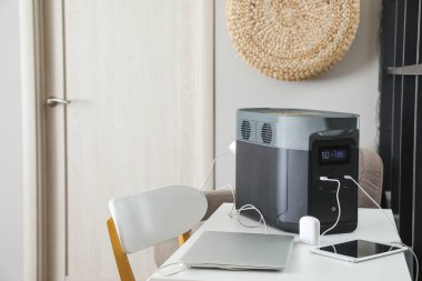 Portable power station charging devices on table in office