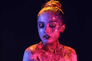 Young woman with glitter makeup on dark background, closeup