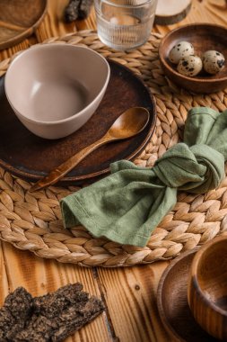 Beautiful table setting with plates, bowl and quail eggs on wooden background