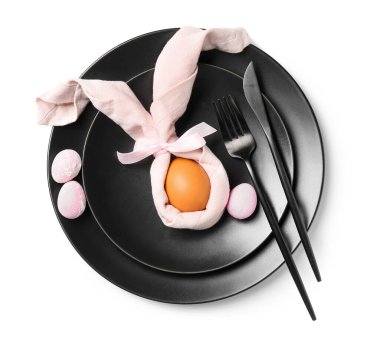 Stylish table setting with black plates and Easter eggs on white background